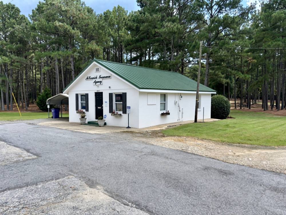 McCormick Insurance Agency office at 2517 U.S. Highway 378 East, a white building with a green metal roof among pine trees